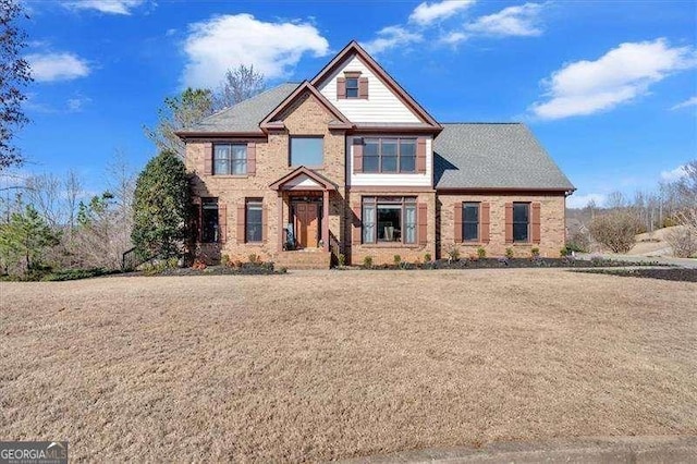 view of front of house featuring brick siding and a front lawn