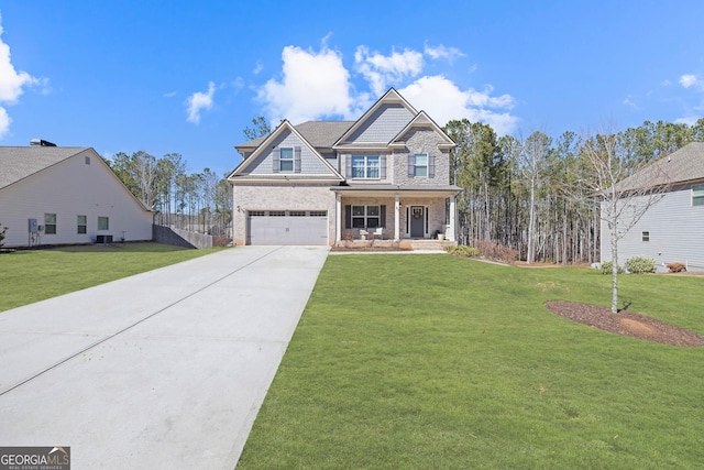 craftsman-style home with covered porch, driveway, a front yard, and an attached garage