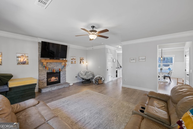 living area with ornamental molding, light wood-type flooring, and visible vents