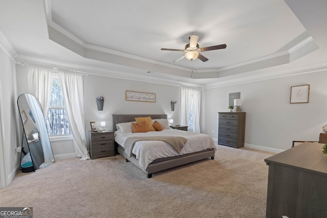 bedroom with baseboards, a tray ceiling, crown molding, and light colored carpet