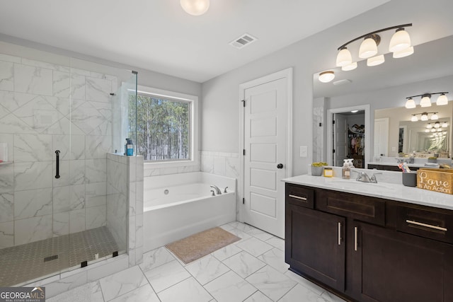 full bathroom with a garden tub, vanity, visible vents, marble finish floor, and a spacious closet