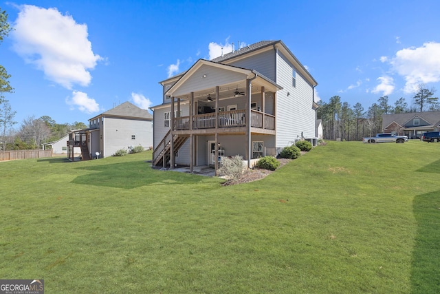 back of property with fence, a ceiling fan, stairs, a lawn, and a wooden deck