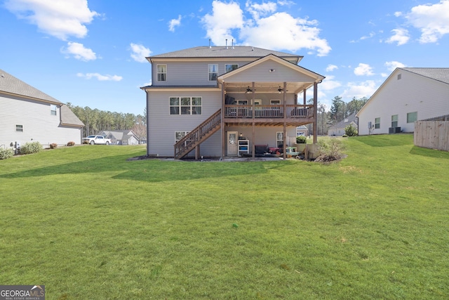 rear view of house with ceiling fan, stairs, a lawn, and a wooden deck