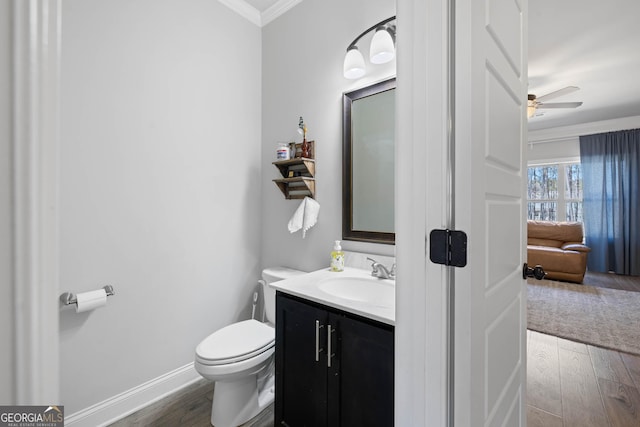 bathroom featuring vanity, wood finished floors, toilet, and crown molding