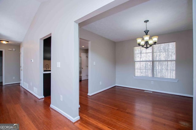 interior space with baseboards, visible vents, dark wood-style flooring, a chandelier, and a sink