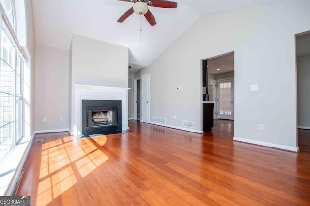 unfurnished living room featuring a fireplace with flush hearth, visible vents, baseboards, and dark wood-style floors