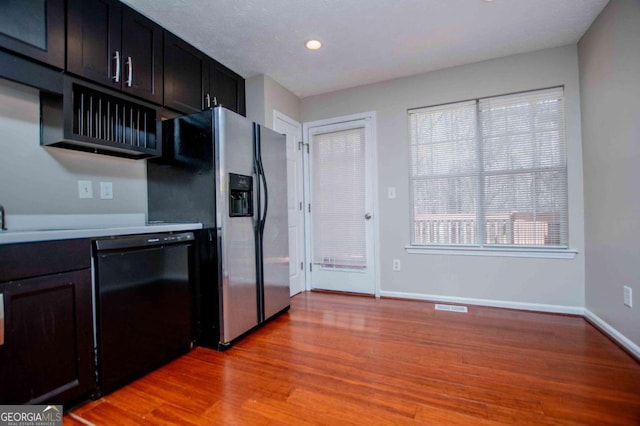 kitchen featuring stainless steel refrigerator with ice dispenser, visible vents, light countertops, light wood-style flooring, and dishwasher