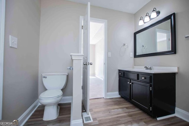 bathroom with vanity, baseboards, and wood finished floors