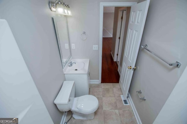 bathroom featuring visible vents, toilet, vanity, tile patterned flooring, and baseboards