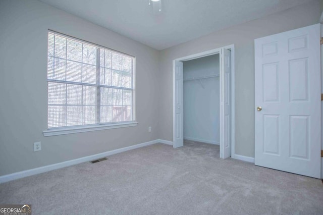 unfurnished bedroom with light carpet, baseboards, visible vents, a ceiling fan, and a closet