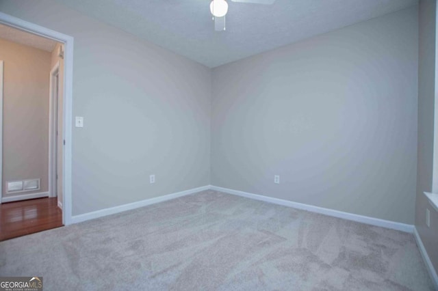 unfurnished room featuring ceiling fan, baseboards, a textured ceiling, and light colored carpet