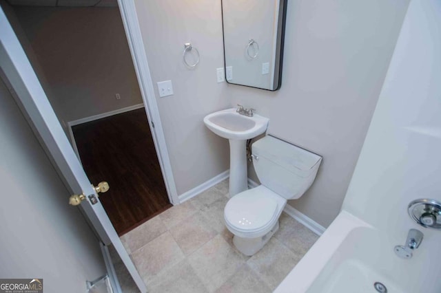 full bath with baseboards, toilet, and tile patterned floors