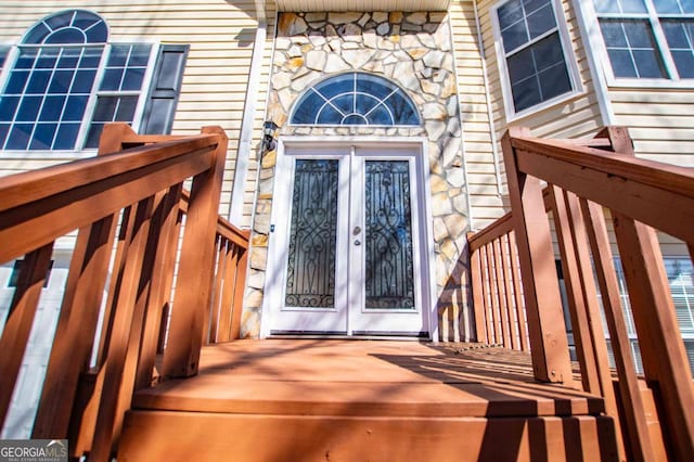 property entrance featuring stone siding and french doors