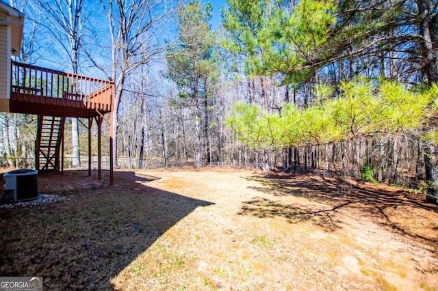 view of yard with stairs, central AC unit, a fenced backyard, and a wooden deck