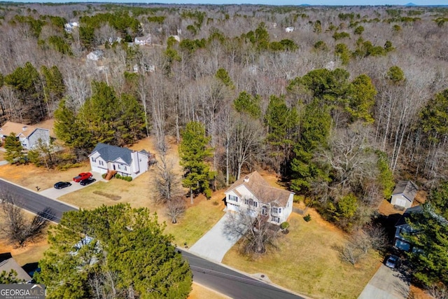 bird's eye view with a wooded view