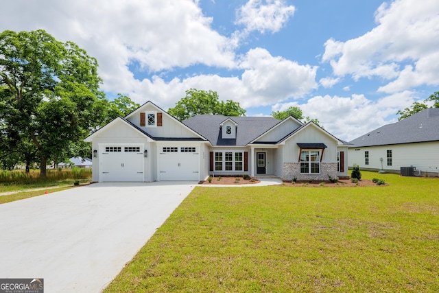 modern farmhouse with brick siding, board and batten siding, a front yard, a garage, and driveway