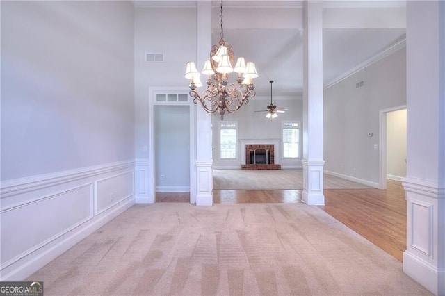 interior space featuring a fireplace, visible vents, a decorative wall, and ornamental molding