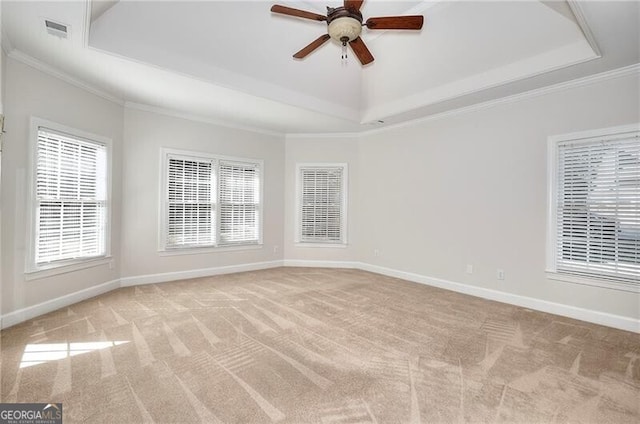 spare room with light carpet, a raised ceiling, visible vents, and baseboards