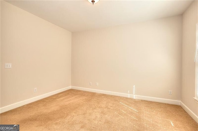 unfurnished room featuring light carpet and baseboards