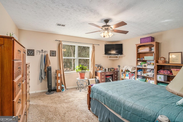 bedroom with light carpet, baseboards, visible vents, and a textured ceiling