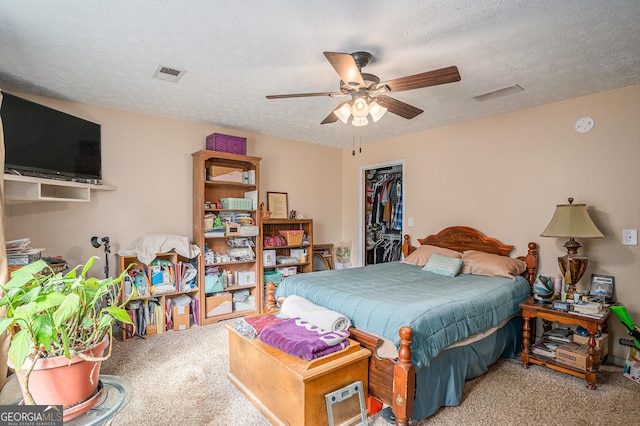 carpeted bedroom with ceiling fan, a closet, visible vents, and a textured ceiling