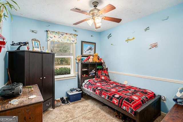 bedroom featuring carpet floors, ceiling fan, and a textured ceiling