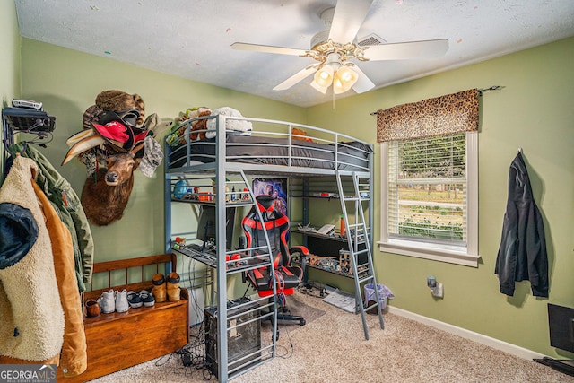 carpeted bedroom with a textured ceiling, baseboards, and a ceiling fan