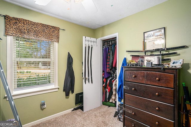 bedroom with a textured ceiling, a ceiling fan, baseboards, a closet, and carpet