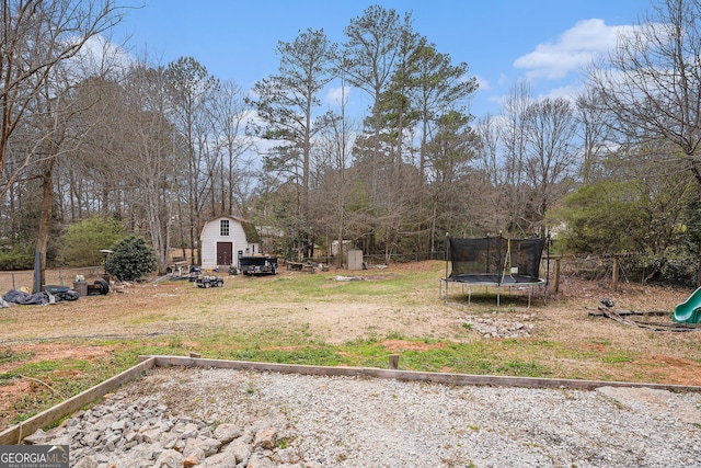 view of yard with a trampoline, a storage unit, and an outdoor structure