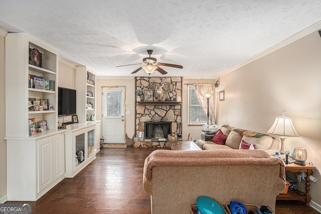 living area featuring a ceiling fan, dark wood finished floors, a textured ceiling, and a stone fireplace