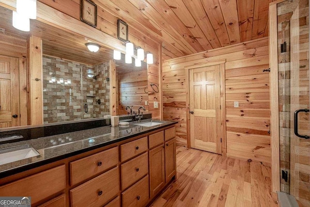 full bathroom with wooden ceiling, wooden walls, wood finished floors, a sink, and a stall shower