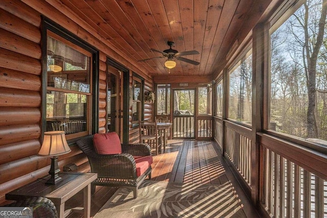 unfurnished sunroom featuring wood ceiling and a ceiling fan