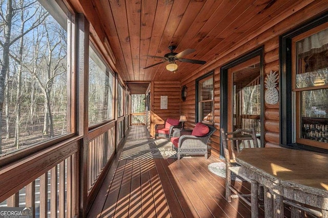 sunroom featuring wood ceiling and ceiling fan