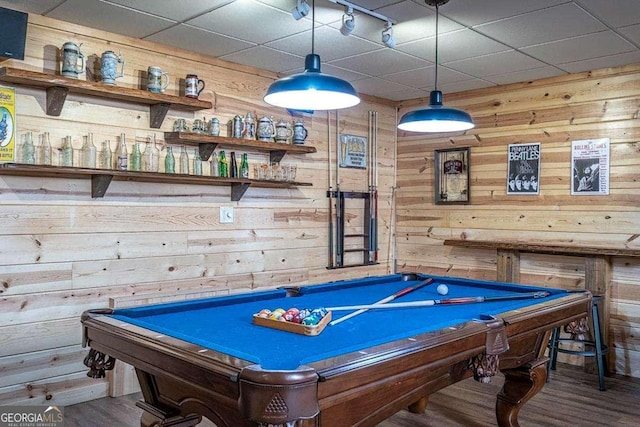 rec room with pool table, wood finished floors, a paneled ceiling, and wooden walls