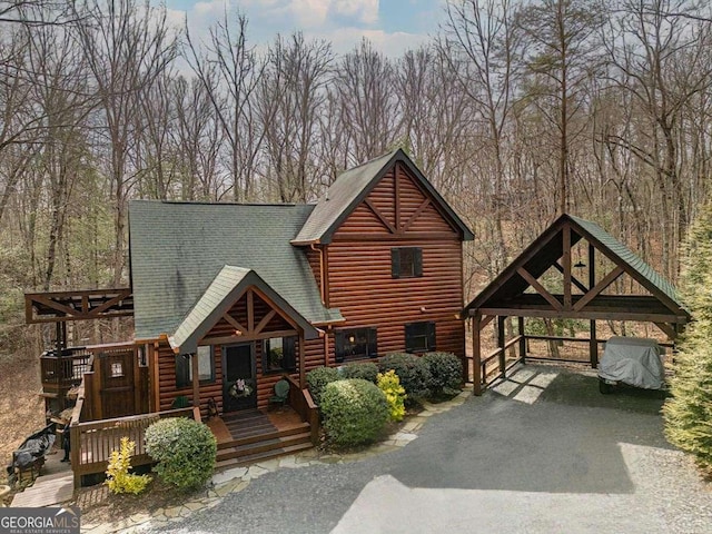 cabin featuring roof with shingles