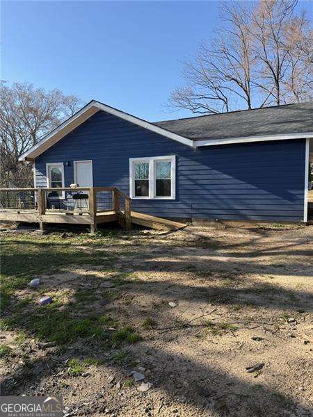 back of house featuring a wooden deck