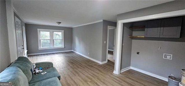 sitting room featuring baseboards, wood finished floors, and ornamental molding