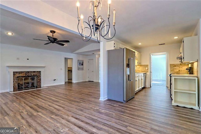 kitchen with high quality fridge, a fireplace, white cabinetry, open floor plan, and light countertops