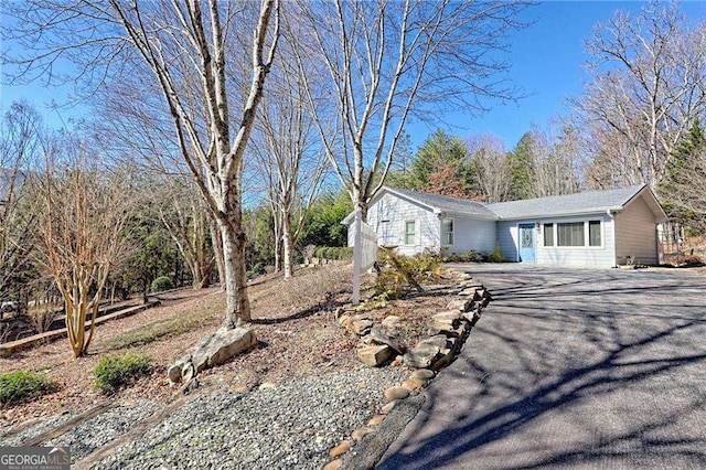 ranch-style home featuring aphalt driveway