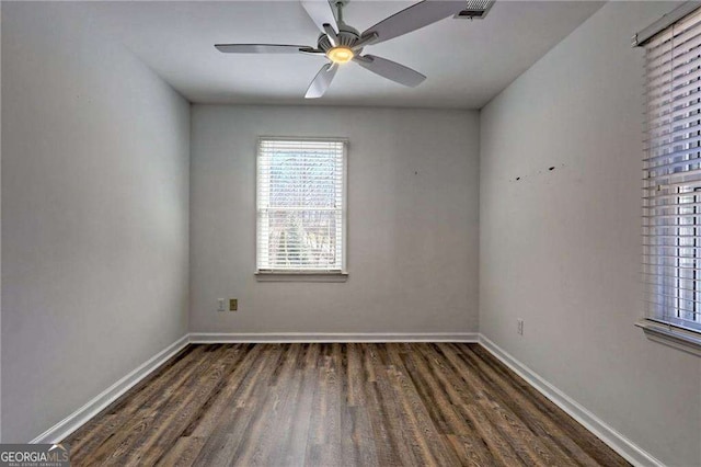 unfurnished room with dark wood-style flooring, visible vents, ceiling fan, and baseboards