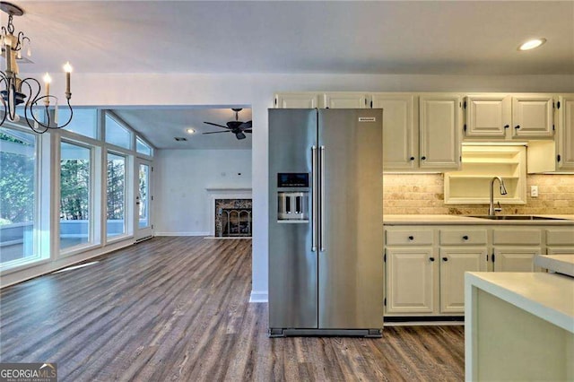 kitchen with dark wood-style flooring, high end fridge, light countertops, white cabinets, and a sink