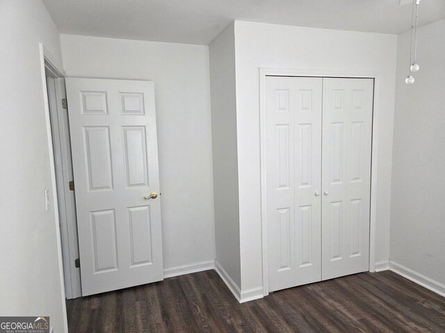 185 Starlight Dr, Sautee Nacoochee, GA 30571 - unfurnished bedroom with dark wood-type flooring, a closet, and baseboards