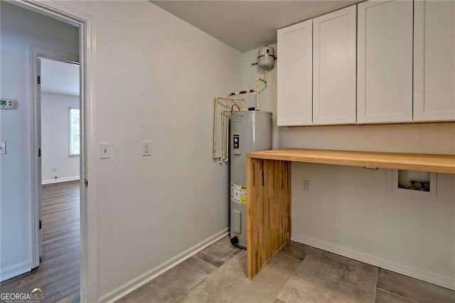 kitchen featuring water heater, butcher block counters, white cabinetry, and baseboards