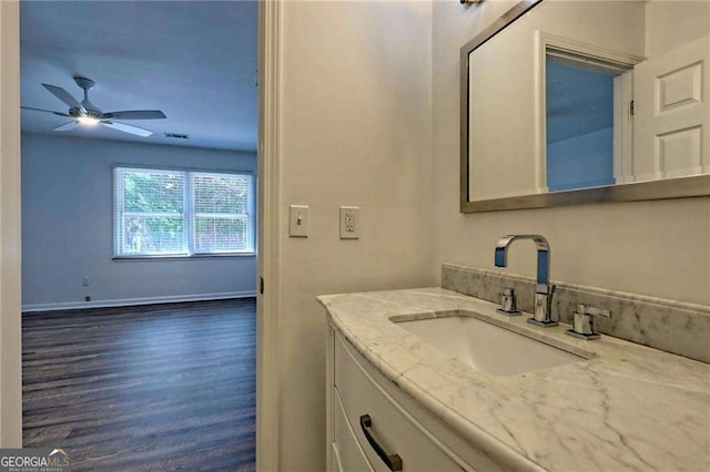 bathroom featuring ceiling fan, wood finished floors, visible vents, vanity, and baseboards