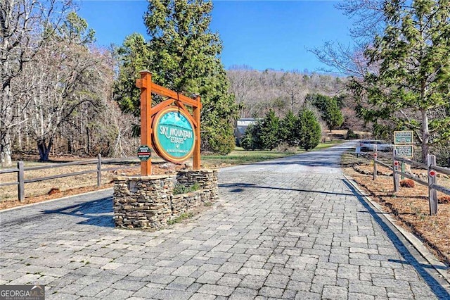 surrounding community with decorative driveway and fence