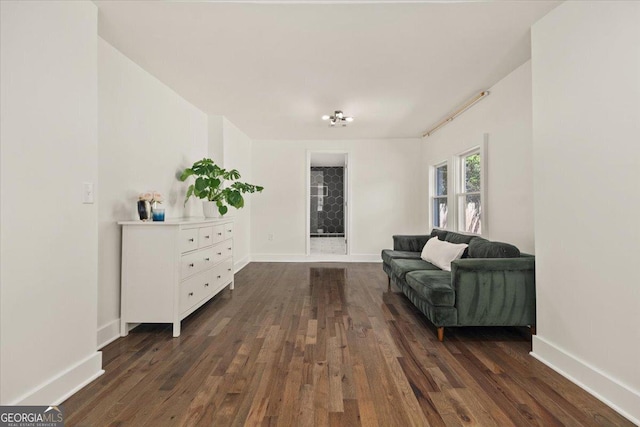 sitting room with dark wood finished floors and baseboards