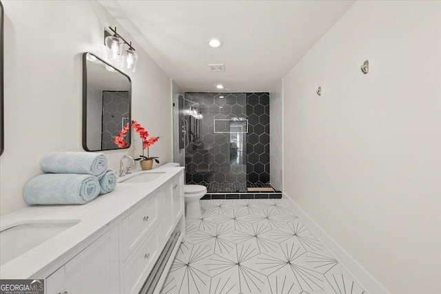 full bathroom featuring double vanity, baseboards, toilet, a shower stall, and a sink