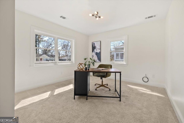 carpeted office featuring baseboards, visible vents, and a chandelier