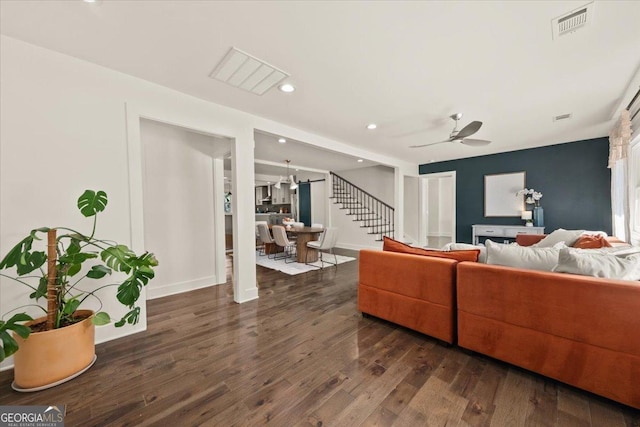 living room featuring recessed lighting, visible vents, dark wood-type flooring, a ceiling fan, and stairs