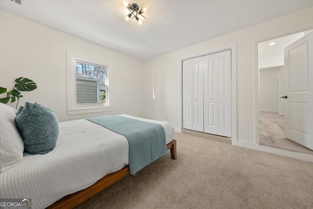 bedroom featuring carpet, visible vents, baseboards, and a closet